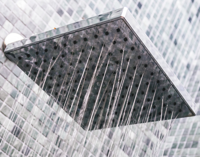 baños Una opción que nunca falla es elegir un plato de ducha rectangular de cerámica blanca, con textura antideslizante y borde bajo, instalado en un baño moderno con azulejos grises y mampara de vidrio transparente.